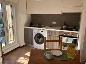 una cucina con lavatrice e piano cottura di Light House: luce e charme come in un piccolo faro a Trieste