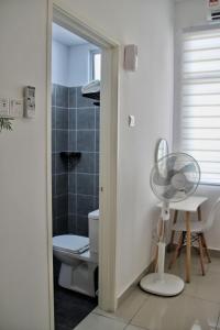 a bathroom with a fan next to a toilet at Homestay Desaru Rock House in Bandar Penawar