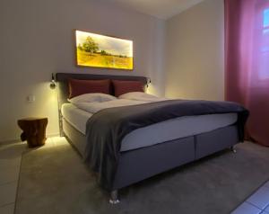 1 dormitorio con 1 cama con una pintura en la pared en An den Bergwiesen en Winterberg