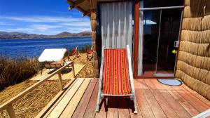 eine Terrasse mit einem Stuhl an der Seite eines Hauses in der Unterkunft TITICACA JALTAWI LODGE in Puno