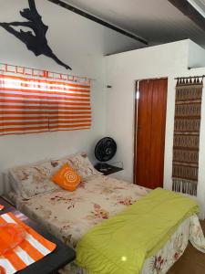 Dormitorio con cama con almohada naranja en Casa ampla de frente ao mar en Cacha Pregos