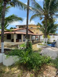 una casa con palmeras delante en Casa ampla de frente ao mar en Cacha Pregos