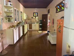een grote keuken met witte kasten en een koelkast bij Casa ampla de frente ao mar in Cacha Pregos