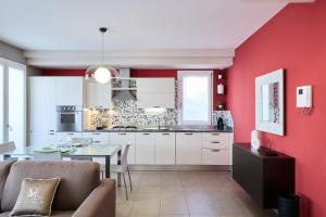 a kitchen with a red wall and a table at Mabellini Lifestyle in Fano