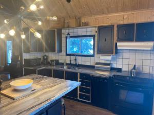 cocina con armarios azules y encimera de madera en LE JAZZ- Chalet rustique/chic avec SPA en Notre-Dame-Des-Bois