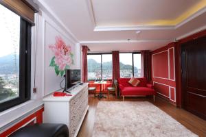 a living room with a red couch and a red chair at Bing Sapa Hotel in Sa Pa