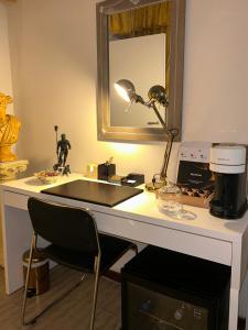 a desk with a lamp and a mirror on it at DolceVita Suite Boutique in Bologna