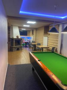a pool table in a room with tables and chairs at Szarotka Wynajem Pokoi in Zakopane