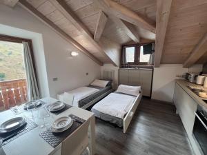 Habitación pequeña con 2 camas y mesa. en Baita Mattia, en Livigno
