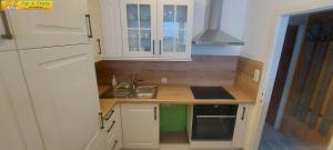 a small kitchen with white cabinets and a sink at Apartment Panoramablick by FiS - Fun in Styria in Bad Mitterndorf