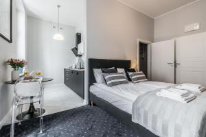a bedroom with a bed and a desk with a chair at SERENITY Residence - Old Town Poznan by Friendly Apartments in Poznań