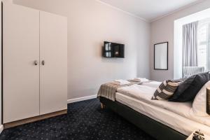 a bedroom with a bed and a white cabinet at SERENITY Residence - Old Town Poznan by Friendly Apartments in Poznań