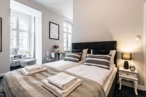 a bedroom with a large bed with two towels on it at SERENITY Aparthotels - Old Town Poznan by Friendly Apartments in Poznań +89 photos