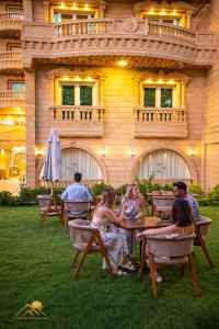 a group of people sitting at tables in front of a building at Pyramids sunrise inn in Cairo
