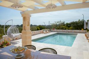 a swimming pool in a patio with a table and chairs at Holiday Home Cosimo in Locorotondo