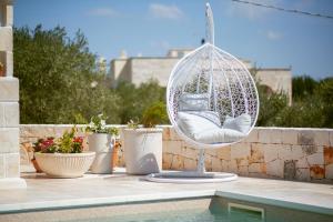 a wicker chair sitting on a patio next to a pool at Holiday Home Cosimo in Locorotondo +96 photos
