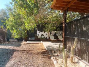 a patio with chairs and a fence and trees at - Magic Bus - in Chlorakas