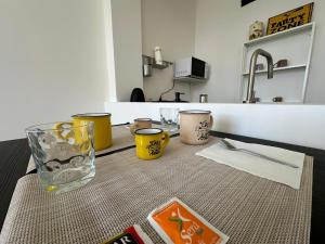 einen Tisch mit drei Tassen und einem Glas darauf. in der Unterkunft La Dimora al Castello in Neapel