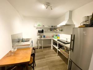 a small kitchen with a table and a refrigerator at Le Cosy (anciennement La Belle Etoile) in Saint-Androny