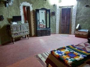 a bedroom with a bed and a mirror and a dressing room at Shilpgram in Bhuj