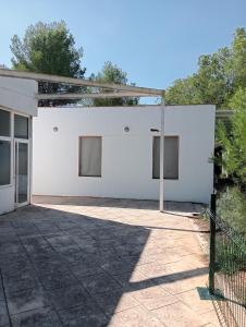 Ein weißes Gebäude mit einem Zaun davor. in der Unterkunft EL PLA DE ESTIVELLA in Estivella