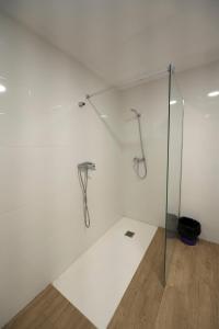 Una ducha en una habitación blanca con una pared de cristal. en EL PLA DE ESTIVELLA en Estivella