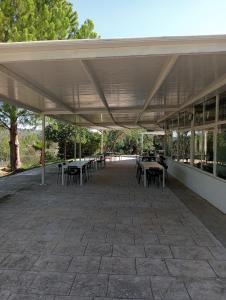 eine Terrasse mit Tischen und Stühlen unter dem Dach in der Unterkunft EL PLA DE ESTIVELLA in Estivella