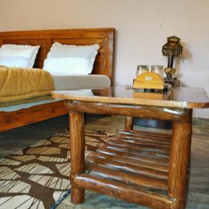 a bedroom with a bed and a wooden table at BAGH VILLA HOME STAY in Rājgarh