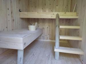 un sauna en bois avec deux étagères et un banc dans l'établissement Gîte de la Bridolée, sauna et bain nordique, à Lorquin