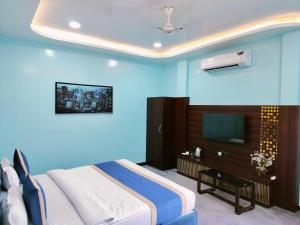 a bedroom with a bed and a tv in it at Hotel Om in Betūl