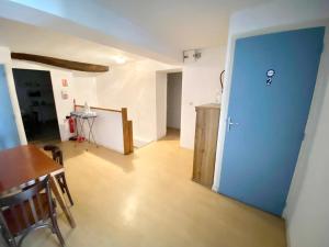 a room with a table and a blue door at Le Cosy (anciennement La Belle Etoile) in Saint-Androny