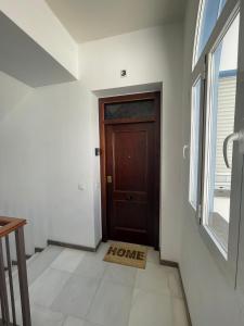 ein Flur mit einer braunen Tür und einem Fenster in der Unterkunft APARTAMENTO LA MAGDALENA in Córdoba
