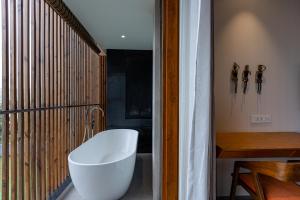 a bathroom with a white bath tub and a window at Radisson Resort and Spa Lonavala in Lonavala