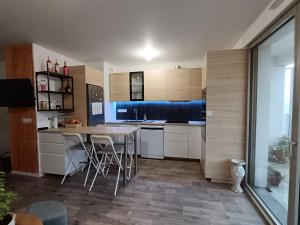 uma cozinha com armários brancos, uma mesa e um gato em Chambre dans un joli appartement cosy em Bordeaux