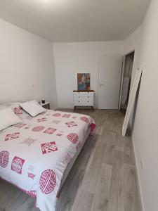 ein weißes Schlafzimmer mit einem Bett und Holzboden in der Unterkunft Chambre dans un joli appartement cosy in Bordeaux