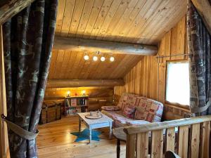 a living room with a couch and a table in a cabin at Chalet en rondins le Bécan tout proche des Ecrins in Les Bosses