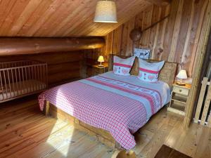 a bedroom with a bed in a log cabin at Chalet en rondins le Bécan tout proche des Ecrins in Les Bosses