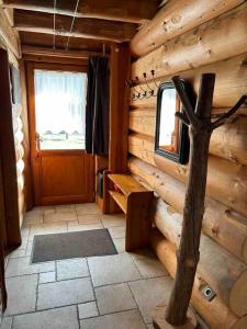 a room in a log cabin with a door at Chalet en rondins le Bécan tout proche des Ecrins in Les Bosses