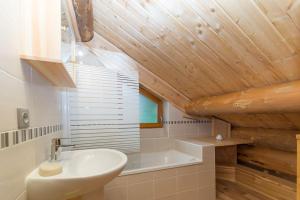 a bathroom with a sink and a bath tub at Chalet en rondins le Bécan tout proche des Ecrins in Les Bosses +30 photos