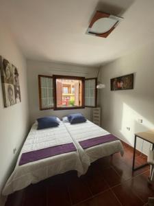 a bedroom with a large bed and a window at Lourdes 1 casa compartida solo con la anfitriona in Breña Baja