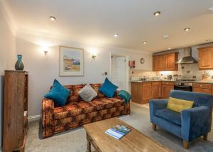 a living room with a couch and a kitchen at Beachcombers in Newquay Bay Resort