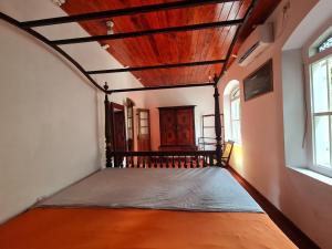 a bedroom with a bed in a room with windows at Hill Side Kings Villa (Colonial Bungalow) in Hikkaduwa