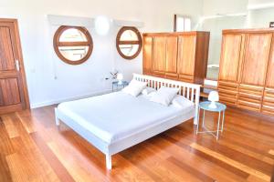 a bedroom with a white bed and two mirrors at Casa Estela in Villaverde +39 photos