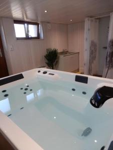 a bathroom with a large white tub in a room at Gîte du Verre au Sabot 5 étoiles avec spa privatif in Soucht +60 photos
