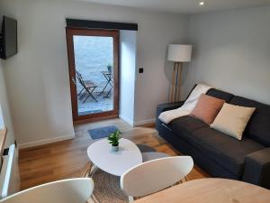 un soggiorno con divano e tavolo di Bulle en Ville Maisonnette de charme a Spa