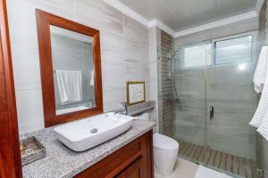 uma casa de banho branca com um lavatório e um chuveiro em 1R apartamentos in Santo Domingo em Villa Mella