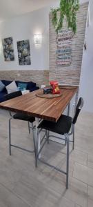 Monolocale Splendida casa vacanze in Tenerife del Sur Casa Mimì في أرونا: طاولة خشبية مع كرسيين في الغرفة
