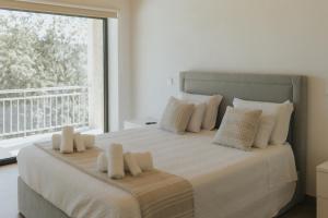 a bedroom with a bed with white pillows and a window at Quinta do Rabelo in Braga