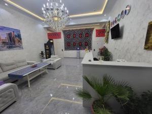 - un salon avec un canapé et un lustre dans l'établissement IMAM AZAM HOTEL, à Samarcande