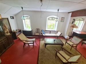 a living room with chairs and a coffee table at Hill Side Kings Villa (Colonial Bungalow) in Hikkaduwa